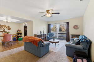 Living area with hanging lights, a ceiling fan, and wood finished floors