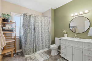 Bathroom with vanity, a textured ceiling, and light tile patterned floors