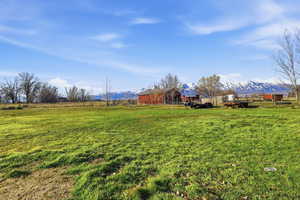 View of green lawn with a mountain view, an outbuilding, and a view of countryside
