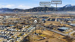 Aerial view of property and surrounding area with nearby suburban area and mountains
