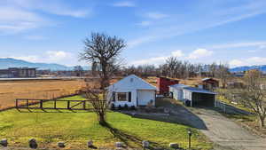 View of yard with a mountain view, concrete driveway, an outdoor structure, a carport, and an outbuilding