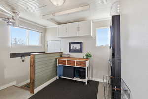 Miscellaneous room with stacked washer and clothes dryer and baseboards