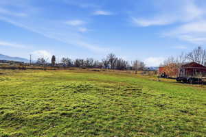 View of grassy yard featuring a rural view and a mountain view