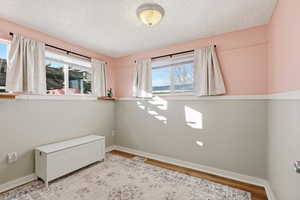 Spare room with wood finished floors and a textured ceiling
