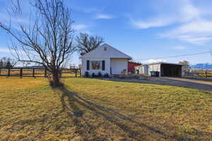 View of front facade with an outbuilding, an outdoor structure, a carport, and driveway