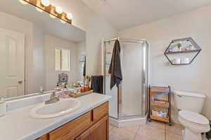 Full bathroom featuring a stall shower, vanity, and light tile patterned floors