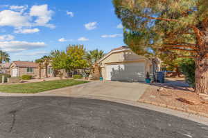 View of front of property featuring concrete driveway, stucco siding, and a front lawn