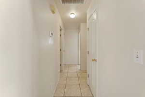 Corridor featuring light tile patterned floors and baseboards