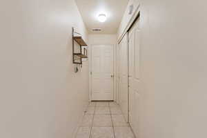 Hallway featuring baseboards and light tile patterned flooring