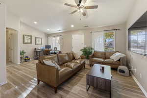Living area with arched walkways, an office area, light wood-style flooring, a ceiling fan, and recessed lighting