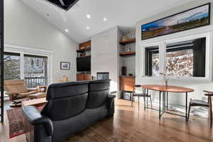 Open Layout Livingroom, Black Walnut and Steel Custom Floating Bar and Entertainment Storage, Tiled Fireplace Designed to Match the Limestone of Hellgate Cliffs, Engineered Hardwood Flooring, Vaulted Ceilings