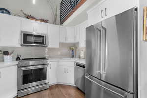 Stainless Appliances, Quartz Countertops, Subway Tile Backsplash, White Cabinets and Storage