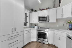 Stainless Appliances, Quartz Countertops, Subway Tile Backsplash, White Cabinets and Storage