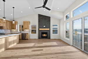 Kitchen with pendant lighting, decorative backsplash, a premium fireplace, dishwasher, and a ceiling fan