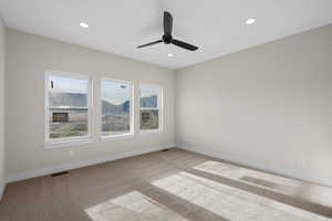 Carpeted empty room with ceiling fan and recessed lighting