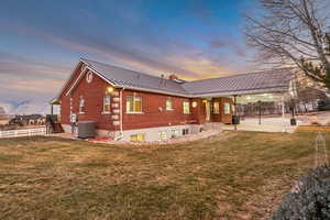 Back of house with brick siding, a patio area, a standing seam roof, and a mountain view
