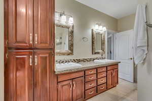 Primary bathroom featuring double vanity and light tile patterned floors