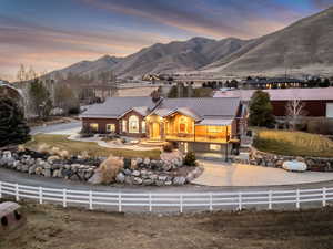 View of front of property featuring a standing seam roof, a chimney, a mountain view, a patio, and stone siding