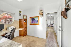 Office area featuring built in desk and baseboards