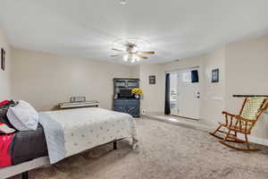 Carpeted bedroom with ceiling fan and baseboards