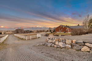 Yard at dusk with a mountain view and an enclosed horse arena