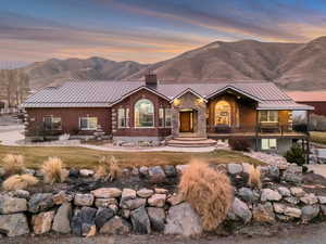 View of front of home featuring a standing seam roof, a chimney, and a mountain view