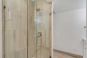 Full bathroom with vanity, a shower stall, and a textured ceiling