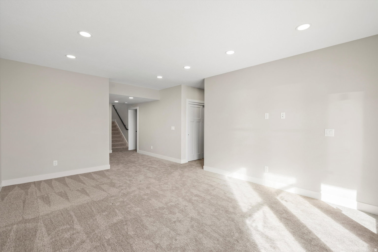 Empty room featuring recessed lighting and light colored carpet