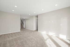 Empty room featuring recessed lighting and light colored carpet