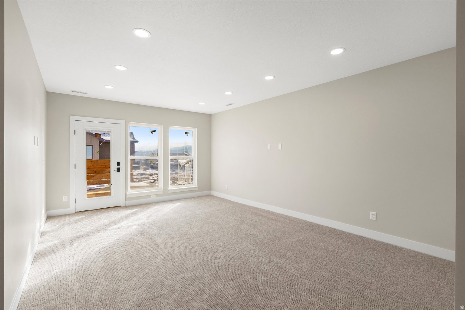 Carpeted empty room with recessed lighting