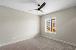 Spare room with carpet floors and a ceiling fan