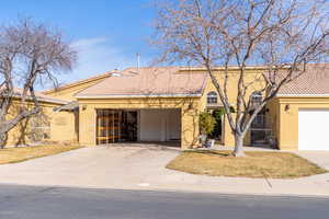 Mediterranean / spanish-style house with a tiled roof, stucco siding, and driveway