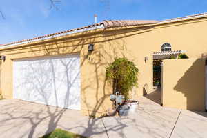 Garage featuring driveway and a gate