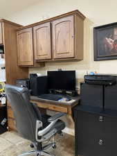 Office area featuring light tile patterned floors and built in study area