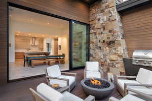 Wooden terrace with a fire pit and an outdoor kitchen and area to lounge