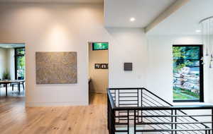 Hall with hardwood / wood-style flooring, an upstairs landing, and recessed lighting
