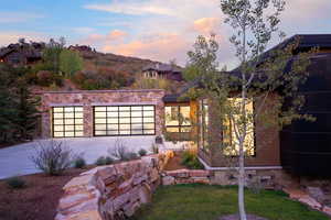 View of front facade featuring stone siding and driveway