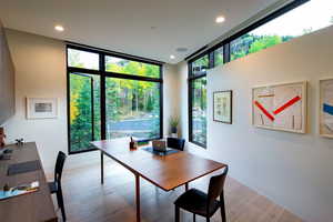 Home office with expansive windows, recessed lighting, and light wood-style flooring