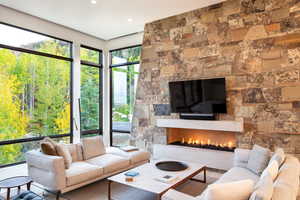 Living area with a stone fireplace and recessed lighting