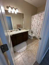 Bathroom featuring vanity, a shower with shower curtain, and light tile patterned floors
