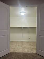 Walk in closet featuring light tile patterned flooring
