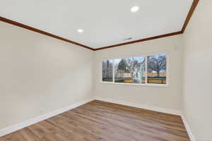 Empty room featuring recessed lighting, light wood-style floors, and ornamental molding