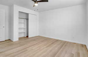 Unfurnished bedroom featuring light wood-style flooring, ceiling fan, and a closet