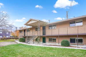 Back of property featuring a lawn and brick siding