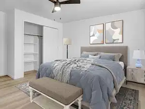 Bedroom with light wood-style flooring, a closet, and ceiling fan