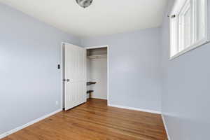Unfurnished bedroom featuring light wood finished floors and a closet