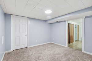 Finished below grade area with baseboards and light colored carpet