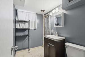 Full bath with vanity, a shower with curtain, and light tile patterned floors