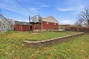 Rear view of property featuring brick siding and basketball court