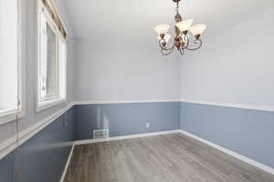 Spare room featuring hanging lights and light wood finished floors
